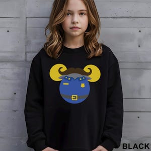May include: Black sweatshirt featuring a cartoon ram wearing a police uniform. The ram has yellow horns, a brown mustache, and a blue uniform with stars and a badge. The word "BLACK" is printed at the bottom right.