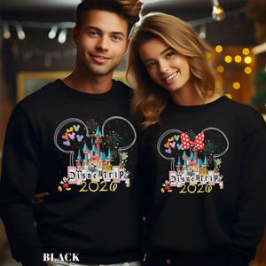 Puede incluir: Sudaderas negras con un dise&ntilde;o de Disney Trip 2020. El dise&ntilde;o presenta un castillo, orejas de Mickey Mouse, fuegos artificiales y corazones coloridos. Una sudadera tiene un lazo rojo de lunares. La palabra "BLACK" est&aacute; en la parte inferior.
