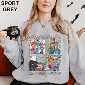 Może przedstawiać: Szara bluza sportowa z kolorową grafiką z kresk&oacute;wek. Grafika zawiera wizerunki lisa, kr&oacute;lika i innych postaci. Na bluzie u g&oacute;ry widnieje napis "SPORT GREY".