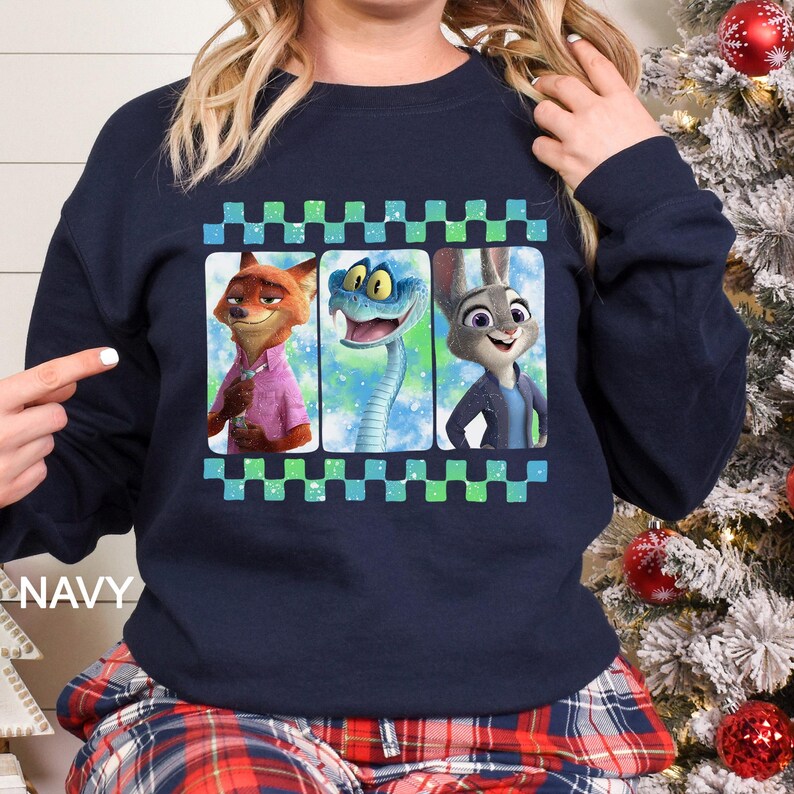 May include: Navy blue sweatshirt featuring a graphic of three animated characters: a fox, a snake, and a rabbit. The design is framed with a green and blue checkered border. The word "NAVY" is printed on the bottom left.