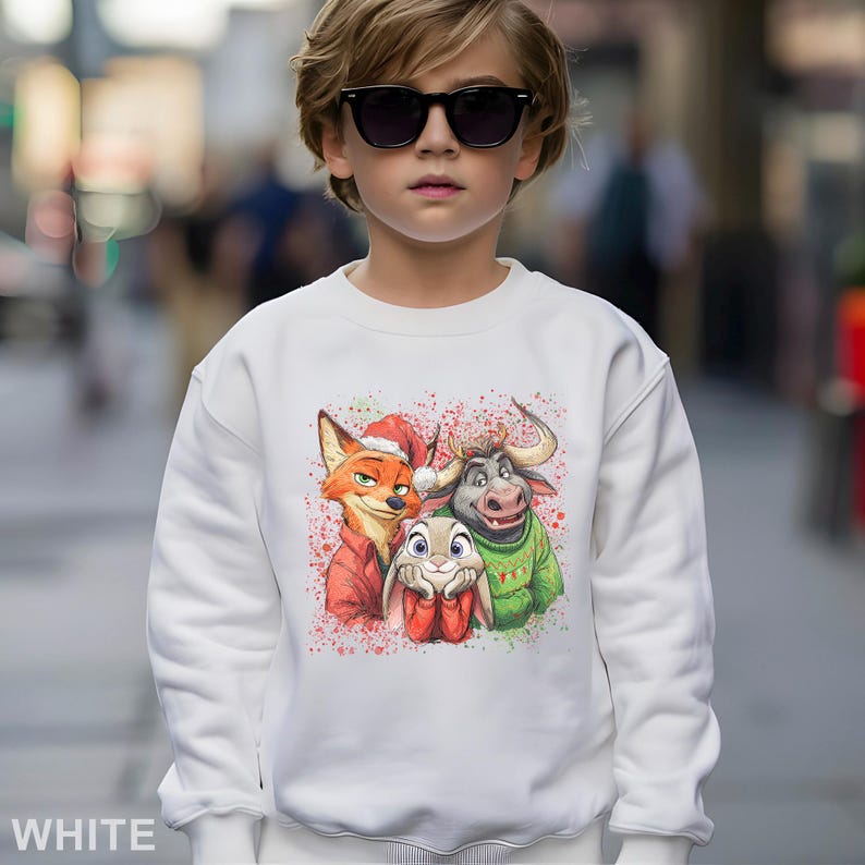 May include: White sweatshirt featuring a colorful graphic of three cartoon characters: a fox in a Santa hat, a buffalo, and a bunny. The design is accented with red and green speckles. The word "WHITE" is printed at the bottom.