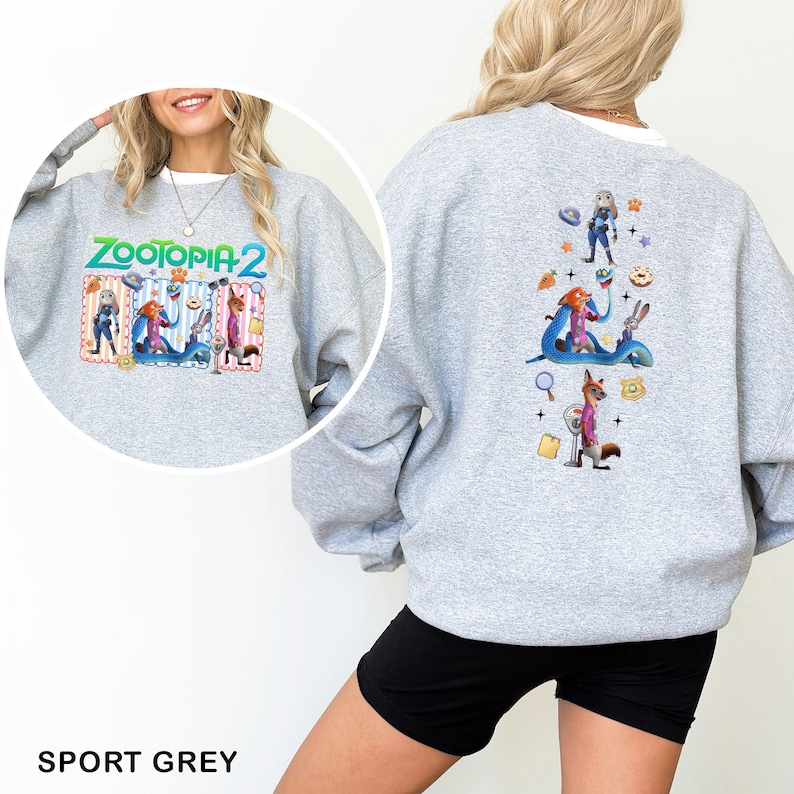 May include: Sport grey sweatshirt featuring the text "ZOOTOPIA 2" with cartoon characters on the front. The back of the sweatshirt has a vertical design with more cartoon characters and icons. The sweatshirt is made of a soft material.