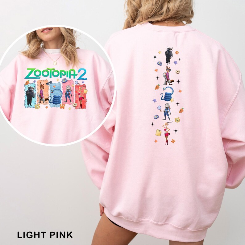 K&ouml;nnte beinhalten: Hellrosa Sweatshirt mit dem Schriftzug "ZOOTOPIA 2" und Cartoonfiguren. Auf der R&uuml;ckseite befindet sich ein vertikales Design mit Cartoonfiguren und Sternen. Der untere Teil des Bildes tr&auml;gt den Text "LIGHT PINK".