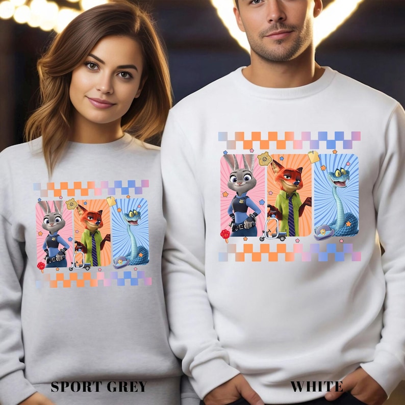 May include: Sport grey and white sweatshirts featuring a colorful graphic of cartoon characters. The design includes a bunny, fox, and snake, each in a unique pose with a vibrant background. The text "SPORT GREY" and "WHITE" are at the bottom.