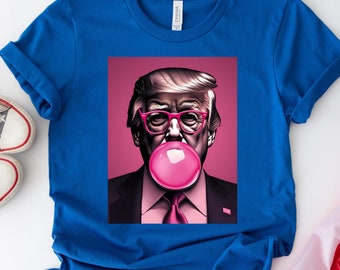 May include: A blue t-shirt with a graphic print of a person blowing a pink bubble. The person is wearing pink glasses and a pink tie. The background of the graphic is pink.