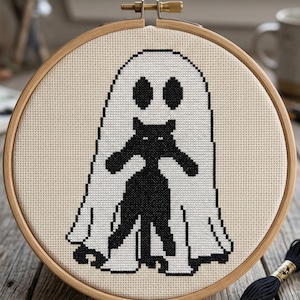 K&ouml;nnte beinhalten: Kreuzstichmuster mit einer schwarzen Katze in einem wei&szlig;en Geisterkost&uuml;m, in einem h&ouml;lzernen Stickrahmen. Der Text "CROSS STITCH PATTERN - INSTANT DOWNLOAD" befindet sich oben.