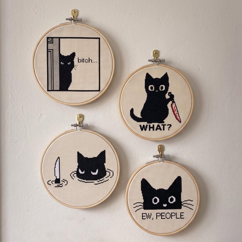 Peut inclure: Quatre tambours &agrave; broder circulaires en bois contenant des points de croix de chats noirs. L'un montre un chat qui regarde avec le texte "bitch...", un autre un chat tenant un couteau avec "WHAT?", un chat dans l'eau et "EW, PEOPLE".