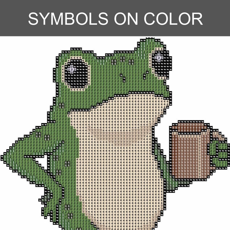 May include: A cross-stitch pattern featuring a green frog holding a brown mug. The design is composed of a grid of squares, each marked with a specific number corresponding to a color. The text SYMBOLS ON COLOR is printed at the top of the image.