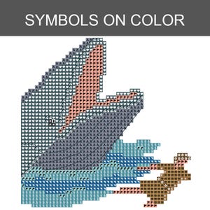 May include: A cross-stitch pattern chart titled SYMBOLS ON COLOR featuring a pixelated design of a whale breaching the water. The pattern uses various symbols like letters, hearts, and flags to represent different colors in shades of blue, gray, and tan.