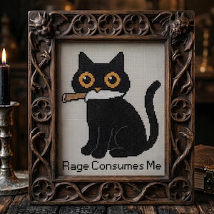 May include: Cross-stitch design of a black cat with yellow eyes and a cigarette, in a dark wood frame. The text "Rage Consumes Me" is below the cat. The frame has decorative carvings. The image is a cross stitch pattern.