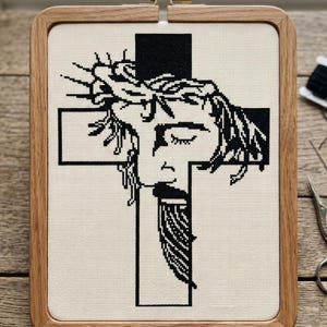 Può includere: Schema a punto croce con immagine in bianco e nero di una figura con corona di spine su una croce, incorniciato in un telaio di legno. Il testo "CROSS STITCH PATTERN - INSTANT DOWNLOAD" è in alto. Download immediato.