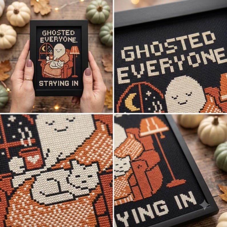 May include: A framed cross-stitch embroidery featuring a ghost sitting in an orange armchair with a cat, a mug, and a lamp. The text reads GHOSTED EVERYONE. STAYING IN. The design uses black, white, and orange thread on a dark background.