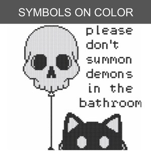 May include: A cross-stitch pattern featuring a skull-shaped balloon and a black cat silhouette. The text reads: please don't summon demons in the bathroom. The design uses a grid of symbols on colour to indicate thread placement for this embroidery project.