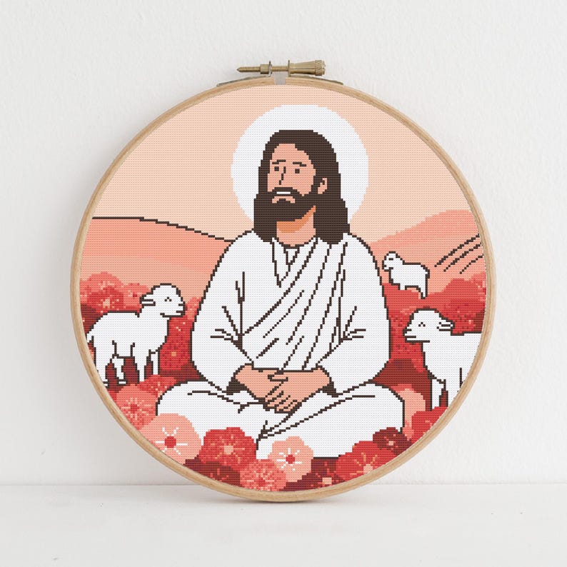 K&ouml;nnte beinhalten: Ein runder Kreuzstich-Stickrahmen mit einem pixeligen Bild einer Figur mit Heiligenschein, umgeben von L&auml;mmern und Blumen. Das Design verwendet Rot-, Rosa- und Wei&szlig;t&ouml;ne vor einem pfirsichfarbenen Hintergrund. Der Rahmen ist aus Holz.