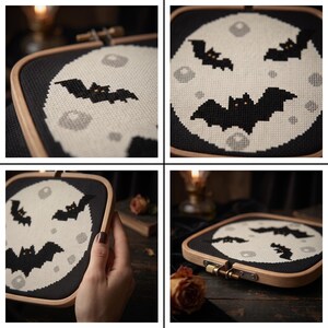 Pu&ograve; includere: Un telaio da ricamo quadrato in legno contenente un lavoro a punto croce che raffigura una grande luna circolare pallida su sfondo nero. Il disegno include diversi pipistrelli neri con piccoli occhi arancioni e crateri circolari grigio chiaro.