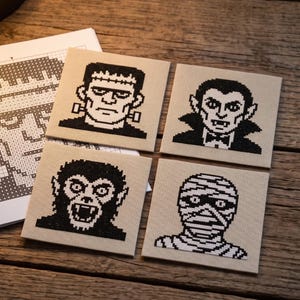 Puede incluir: Cuatro paneles cuadrados de punto de cruz sobre tela beige con retratos pixelados en negro de un monstruo, un vampiro, un hombre lobo y una momia. Cada panel muestra un dise&ntilde;o de personaje de terror distinto junto a una hoja de patr&oacute;n.