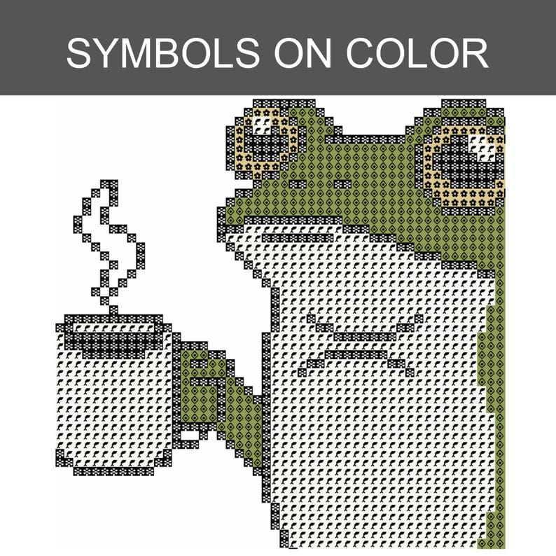 Puede incluir: Un patr&oacute;n de punto de cruz que muestra una rana verde sosteniendo una taza humeante. El dise&ntilde;o utiliza una cuadr&iacute;cula de s&iacute;mbolos sobre color para representar la cabeza, el cuerpo y la taza. El texto SYMBOLS ON COLOR aparece en blanco sobre una barra gris.