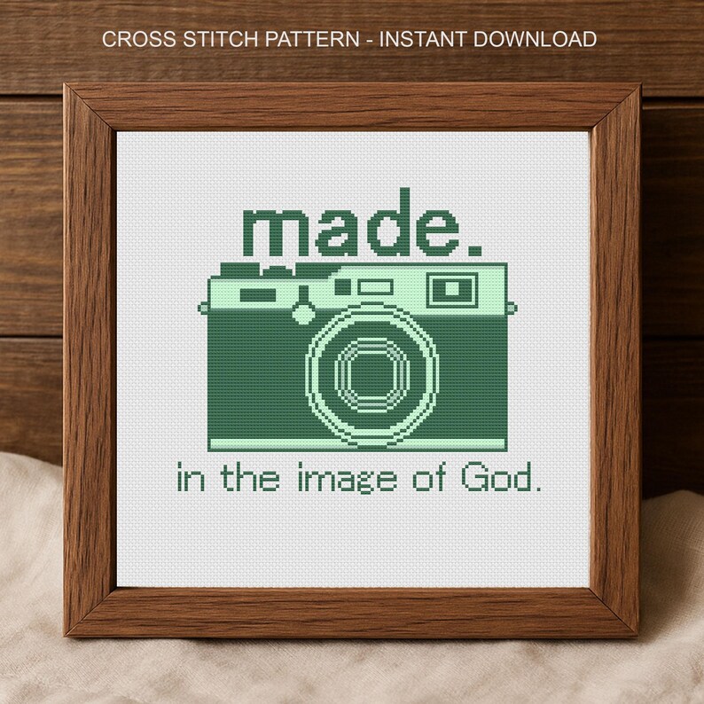 Puede incluir: Un patr&oacute;n de punto de cruz enmarcado con un dise&ntilde;o de c&aacute;mara verde y las palabras "made." y "in the image of God." El marco es de color marr&oacute;n oscuro. El texto "CROSS STITCH PATTERN - INSTANT DOWNLOAD" est&aacute; en la parte superior.