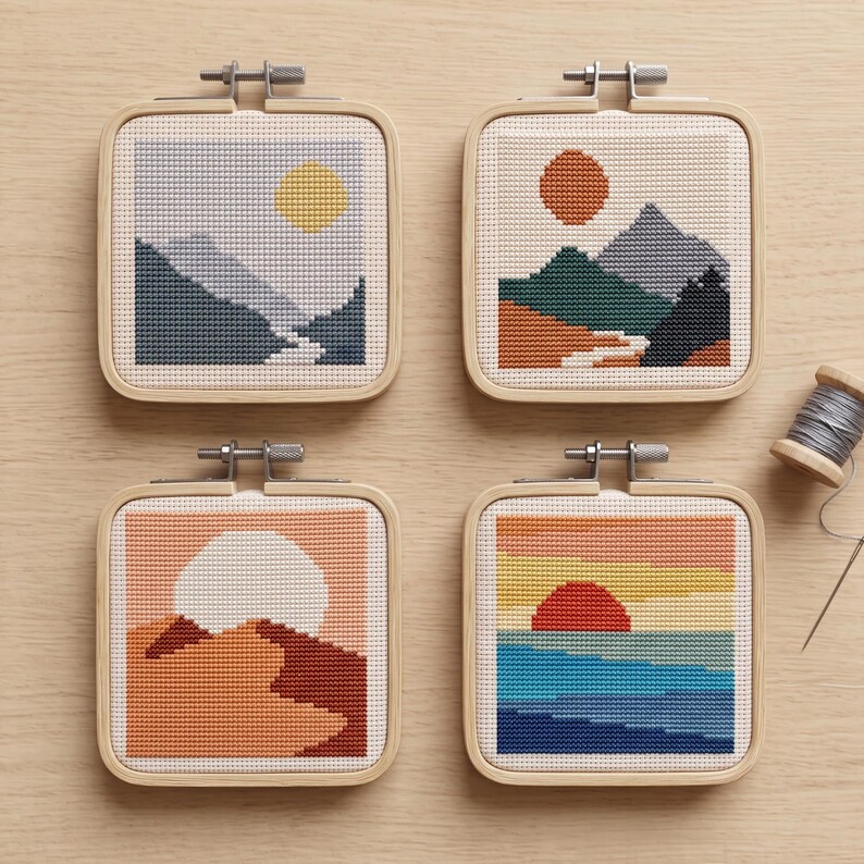 Peut inclure: Quatre tambours &agrave; broder carr&eacute;s pr&eacute;sentant des paysages au point de croix. En haut &agrave; gauche, un soleil jaune sur des montagnes bleues. En haut &agrave; droite, un soleil orange sur des sommets multicolores. En bas &agrave; gauche, un soleil blanc sur des dunes orange. En bas &agrave; droite, un soleil rouge sur une mer bleue.