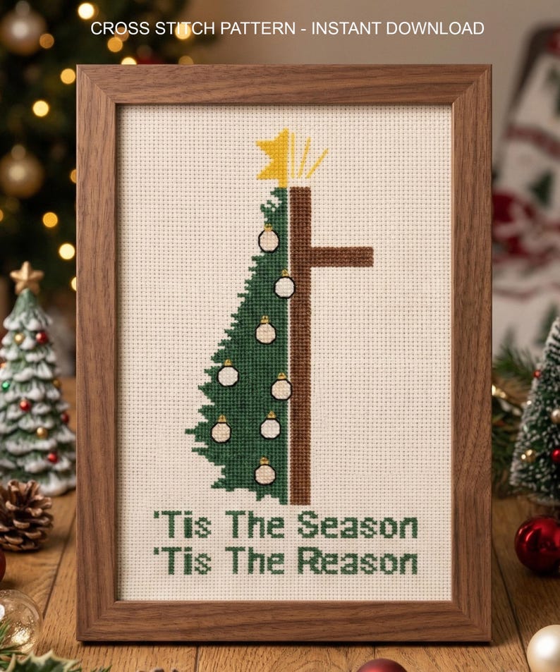 K&ouml;nnte beinhalten: Ein gerahmtes Kreuzstichmuster mit einem Weihnachtsbaum-Design, kombiniert mit einem Kreuz. Der Baum ist gr&uuml;n mit wei&szlig;en Kugeln, und das Kreuz ist braun. Der Text "'Tis The Season, 'Tis The Reason" steht unten. Der Rahmen ist aus Holz.