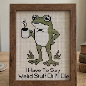 May include: Cross-stitch pattern in a wooden frame featuring a green frog holding a coffee cup. The frog has an annoyed expression. Text reads "I Have To Say Weird Stuff Or I'll Die." The top of the frame reads "CROSS STITCH PATTERN - INSTANT DOWNLOAD."
