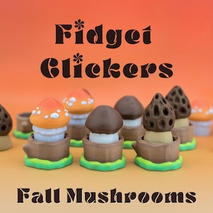May include: A selection of mushroom-shaped fidget toys in various colours. The toys have orange, brown, and white caps, with a green base and brown wooden-like details. The text "Fidget Clickers" and "Fall Mushrooms" are displayed.