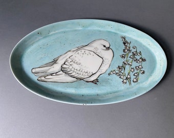 Pigeon blanc et muguet - une assiette en porcelaine