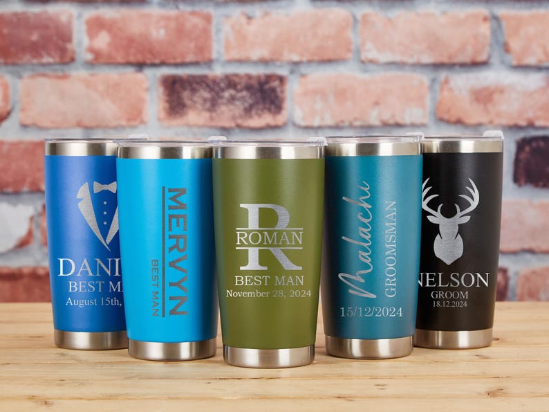 May include: Five stainless steel insulated tumblers in various colors, each with personalized text and designs. The tumblers feature names, dates, and titles like "Best Man" and "Groom". The designs include a tuxedo, a deer head, and initials.