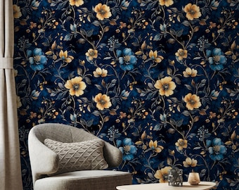 May include: A navy blue floral wallpaper with yellow and blue flowers. A gray armchair with a gray knitted pillow sits in front of the wallpaper. A wooden coffee table with a black metal candle holder and a glass candle sits in front of the chair.