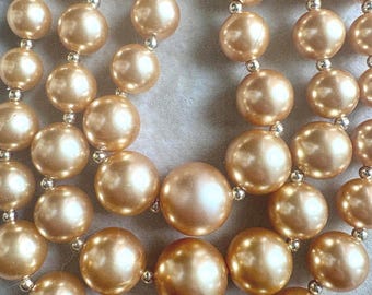 A Vintage Costume Triple Strand of Gold Graduated Beads with Gold Tone Findings