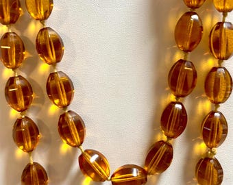 An Antique Flapper Necklace with Hand Knotted Amber Glass Beads