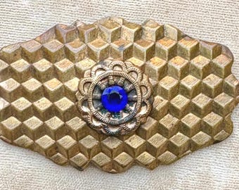 An Antique Art Deco Brass Brooch with a Honeycomb Pattern and a Cobalt Blue Faceted Center Stone