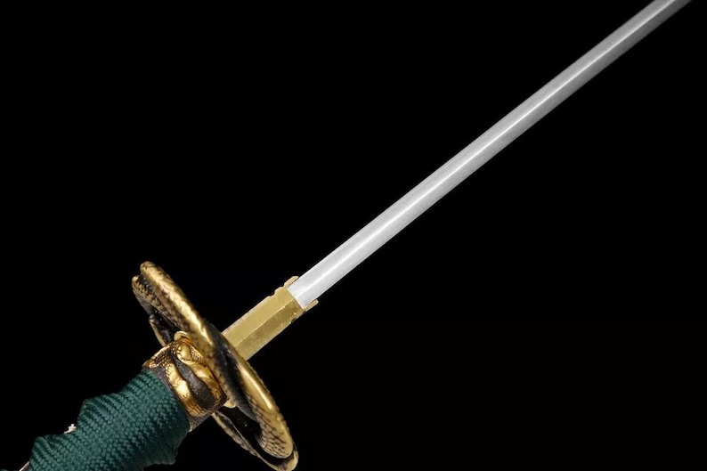 May include: A detailed view of a Japanese katana sword. The blade is silver, the hilt is gold and green, and the guard is a decorative gold design. The sword is set against a black background.