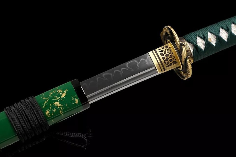 May include: Close-up of a katana sword with a black blade and a green handle. The handle is wrapped in black cord and features gold accents. The blade has a unique pattern, and the guard is gold.