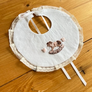 Collezione “Dondolo”: Bavaglino in lino bianco ricamato a mano Personalizzabile e/o “telo coccola” abbinato e/o porta ciuccio