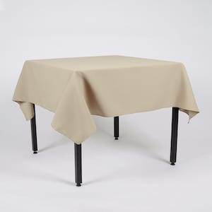 May include: A beige square tablecloth draped over a black table with four legs. The tablecloth has a smooth texture and hangs down the sides of the table.