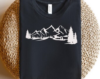 Könnte beinhalten: Ein schwarzes T-Shirt mit einer weißen Silhouette einer Bergkette und Bäumen. Die Berge sind gezackt und die Bäume sind hoch und schlank.