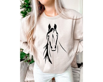 May include: A beige sweatshirt with a black silhouette of a horse's head.