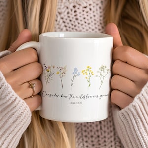 May include: White ceramic mug with a floral design and the text "Consider how the wildflowers grow" and "Luke 12:27".
