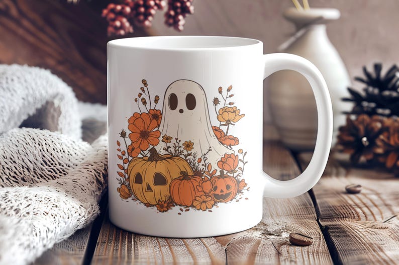 May include: White ceramic mug featuring a Halloween-themed design. The design includes a ghost, pumpkins, and orange flowers. The mug has a large handle and is set on a wooden surface.