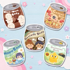 Op de afbeelding: Vijf ge&iuml;llustreerde stickers van frisdrankblikjes met stripfiguren. De blikjes zijn gelabeld als Woro-Woro Soda, Cotbus Soda, Arriety Soda met de tekst You forgot something, Haku Soda en Ducksomo Soda, elk met unieke kleuren en ontwerpen.