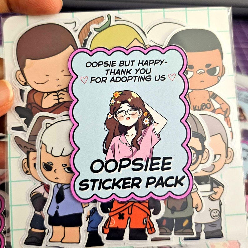 May include: A pack of colorful stickers featuring cartoon characters. The central sticker has a woman with glasses and flowers in her hair, with the text "OOPSIEE STICKER PACK". Other stickers show various cartoon figures. The background is a grid pattern.