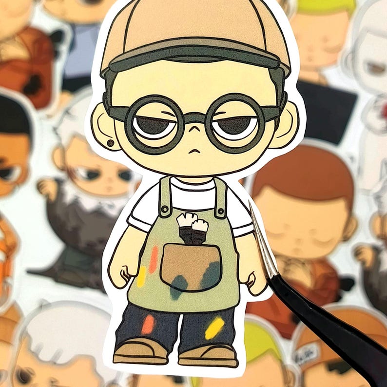 May include: A sticker featuring a cartoon artist character wearing a tan cap, round glasses, and a green apron with paint splotches. The artist is holding a paintbrush. Other similar stickers are in the background.