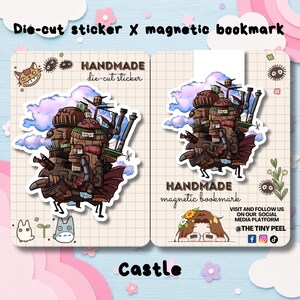 May include: A die-cut sticker and a magnetic bookmark featuring a brown, multi-tiered mechanical castle with pipes, wings, and small houses against blue and purple clouds. The items are displayed on grid-patterned cards with small illustrations.