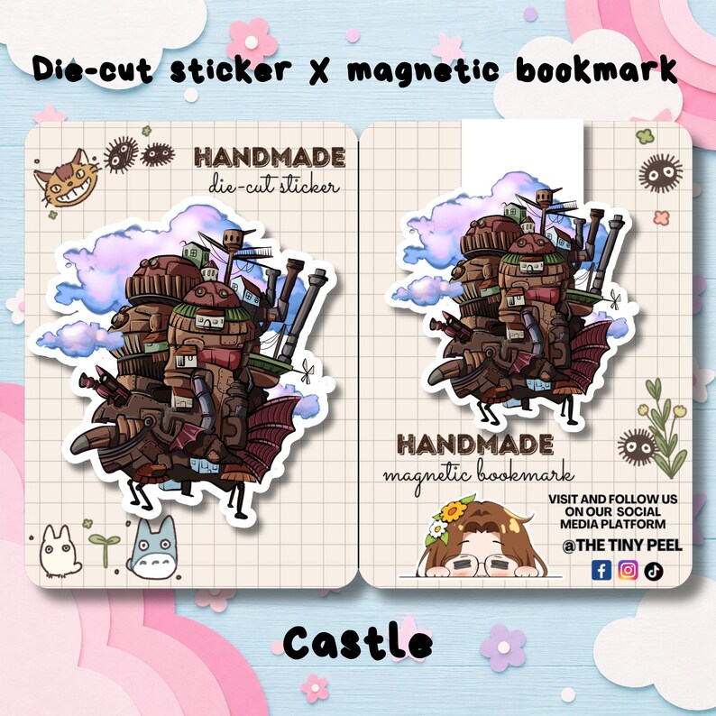 May include: A die-cut sticker and a magnetic bookmark featuring a brown, multi-tiered mechanical castle with pipes, wings, and small houses against blue and purple clouds. The items are displayed on grid-patterned cards with small illustrations.