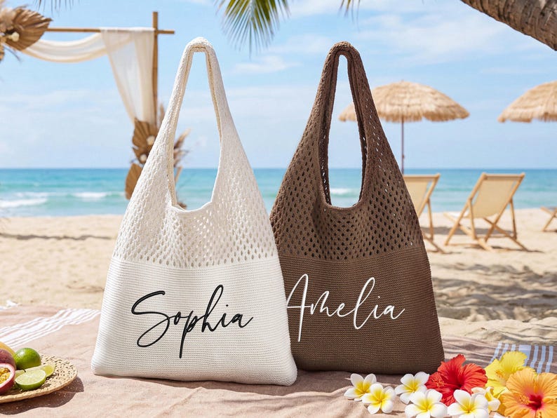 Pu&ograve; includere: Due borse da spiaggia a trama aperta, una color crema e una marrone. La borsa color crema ha il nome "Sophia" in corsivo nero, e la borsa marrone ha "Amelia" in corsivo bianco. Le borse sono su una spiaggia con fiori tropicali.