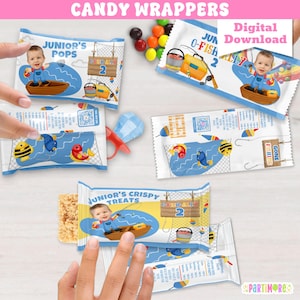 Puede incluir: Envoltorios de caramelos con temática de pesca. Los envoltorios presentan un bebé en un bote, aparejos de pesca y el texto "Junior's Pops", "Junior's Crispy Treats" y "Gone Fishing". Los envoltorios son azules y blancos con ilustraciones de peces coloridos.