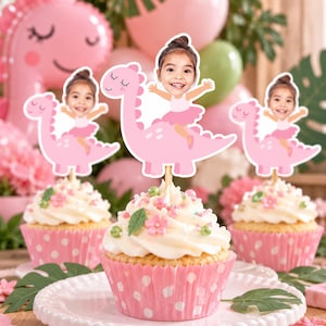 May include: Three cupcakes in pink polka-dot paper liners, each topped with a custom cake topper featuring a photographic cutout of a child's face on an illustrated pink dinosaur with a child wearing a pink tutu and ballet slippers.