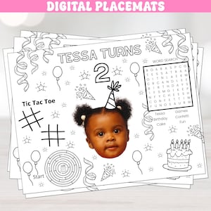 May include: A black and white printable placemat with a birthday theme. The placemat features a word search puzzle, a tic-tac-toe game, a maze, and a picture of a child. The text on the placemat says "Tessa Turns 2".