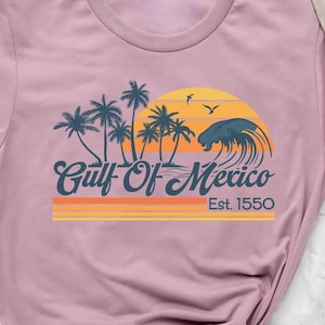 a t - shirt with a sunset and palm trees on it
